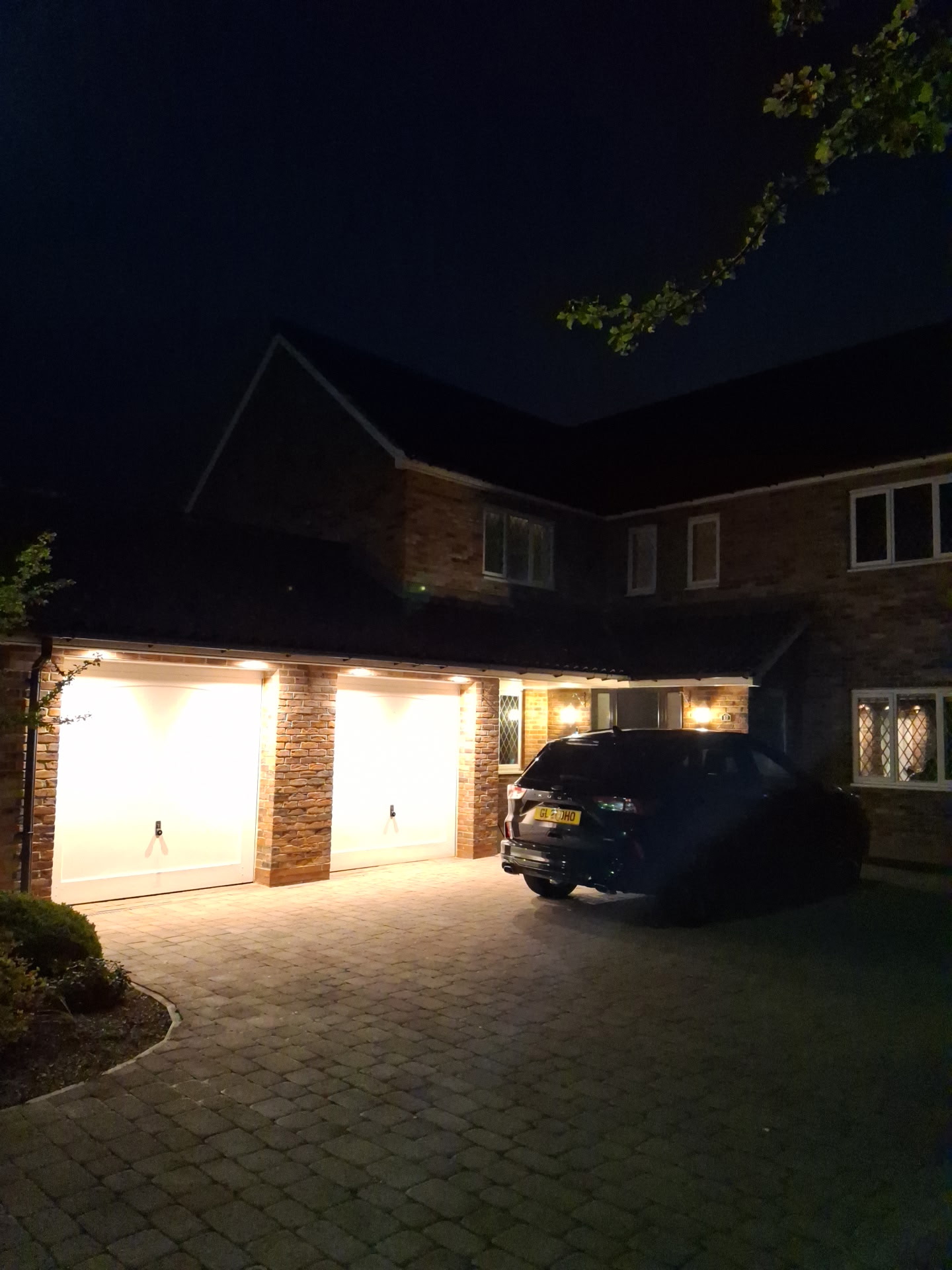 A double garage lit with warm lights at night