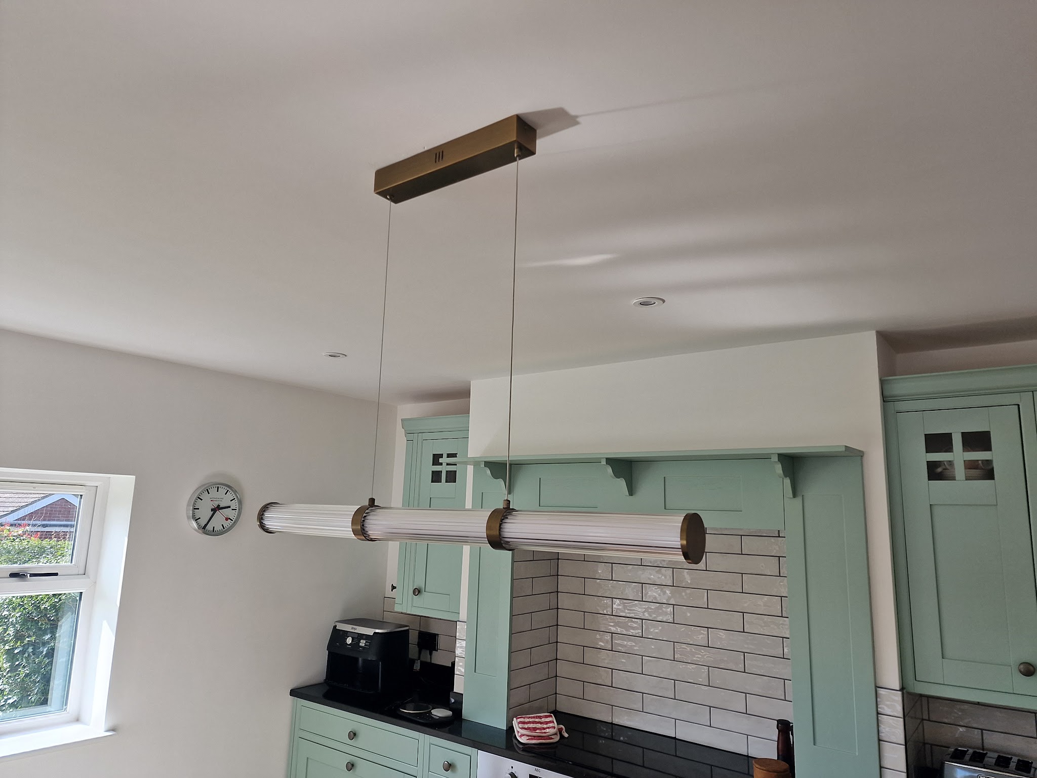 A kitchen with a linear pendant light above the worktop
