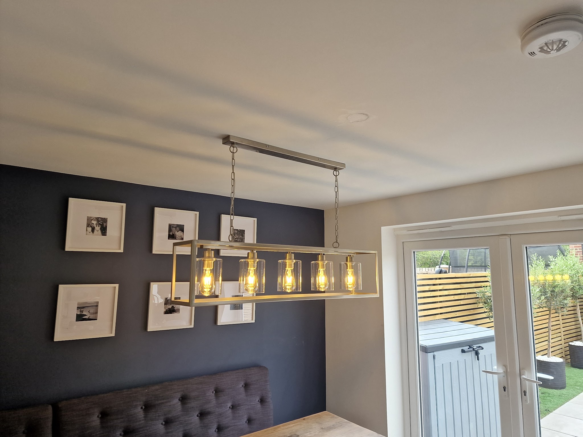 A dining area with an industrial linear pendant light